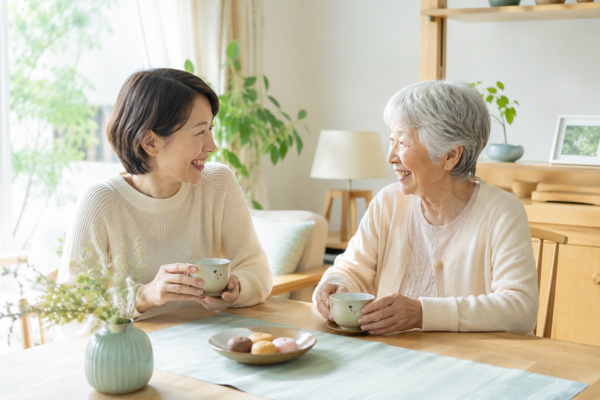 スタッフが高齢の女性とお茶を飲みながら楽しく会話している様子